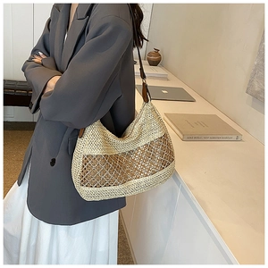 Detail of beige straw shoulder bag with woven mesh pattern and brown leather strap
