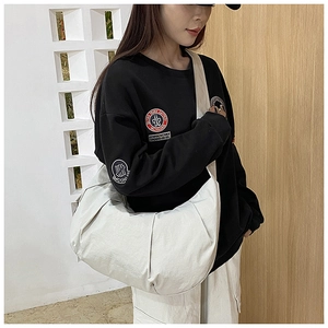 Detail of white large capacity crescent crossbody bag with pleated canvas texture