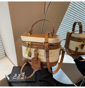 Detail of a chic cream and brown box bag with embossed patterns and adjustable strap