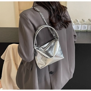 Detail of silver metallic bucket bag with chain strap and micro-wrinkle texture finish