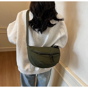Olive green nylon crescent bag with adjustable wide strap shown on model's back