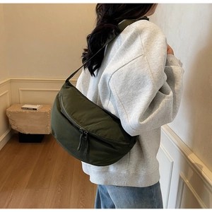 Detail view of army green nylon crescent bag with double zipper and wide strap