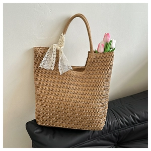Detail der gewebten Stroh-Tote-Bag mit weißem Spitzenband und floralen Tulpen-Akzenten