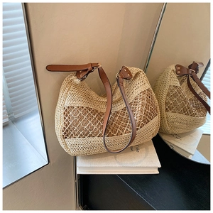 Detailed view of beige straw hobo bag with rope mesh and brown leather strap