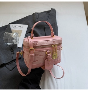 Detailed close-up of pink leather handbag with floral embossing and gold padlock charm