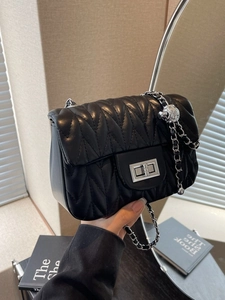 Chic black quilted chain bag with silver turn-lock and decorative metal ball charm