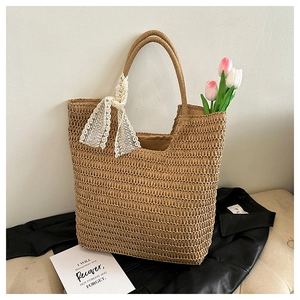 Detail der handgeflochtenen Strohtasche mit eleganter Spitze und großem Innenraum