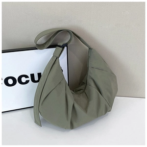 Detailed view of sage green crescent bag with pleated nylon fabric and wide strap