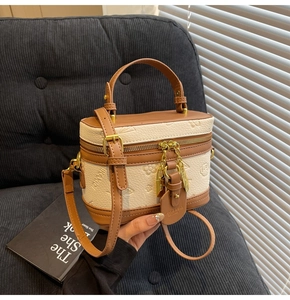 Detail of vintage cream and brown box bag with embossed patterns and gold hardware