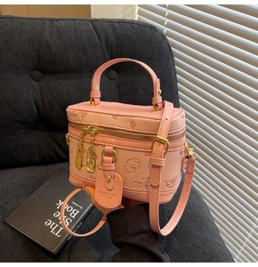 Detail view of pink embossed PU leather crossbody bag with cartoon floral patterns