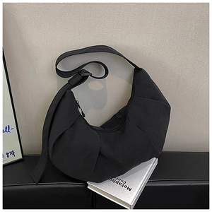 Close-up of black crescent dumpling bag with pleated nylon texture for minimalist styling