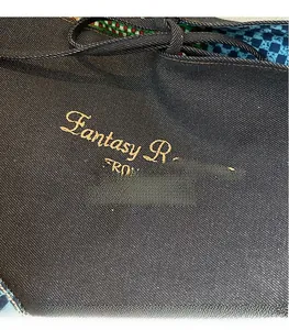 Close-up of gold embroidery on navy denim tote with colorful plaid lining details