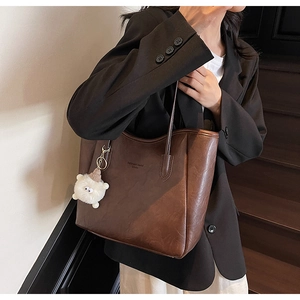 Braune Shopper-Tasche aus Leder mit Fashion Brand Schriftzug und weißem Plüsch-Anhänger