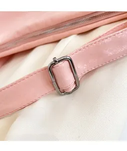 Dettaglio macro della borsa rosa chiaro con tracolla regolabile e fibbia in metallo
