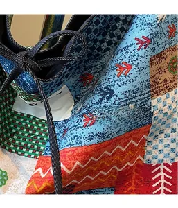 Detailed view of ethnic patchwork tote bag fabric with geometric patterns and drawstrings