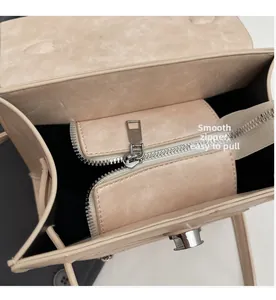 Detail of a beige tote bag featuring a smooth metal zipper and secure interior pocket