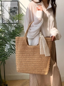 Große geflochtene Strohtasche mit Spitzenschal in stilvollem Innenraum-Lifestyle-Ambiente
