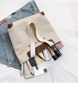 Detail view of large canvas tote bag showing spacious interior with cosmetics and leather trim