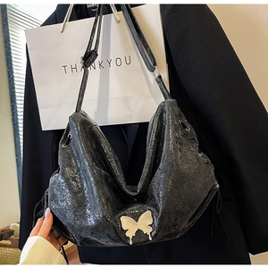 Dettaglio della borsa hobo nera metallizzata con grande farfalla bianca e texture