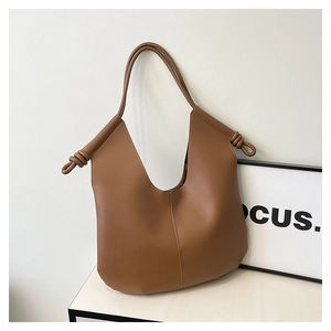 Brown tote bag detail featuring knotted shoulder strap and deep V-cut opening design