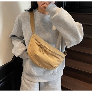 Detailed view of the khaki crescent crossbody bag on a model with adjustable strap