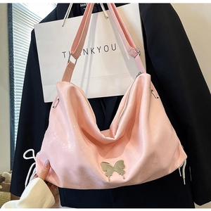 Dettaglio borsa shopper rosa lucida con farfalla in metallo argento e coulisse laterale