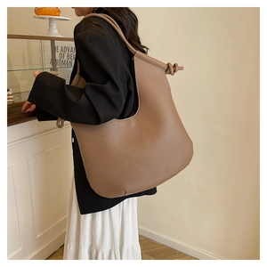 Detail of mocha leather hobo bag featuring a knotted shoulder strap and large capacity