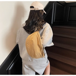Khaki crescent canvas bag worn as a crossbody with adjustable strap for casual commute
