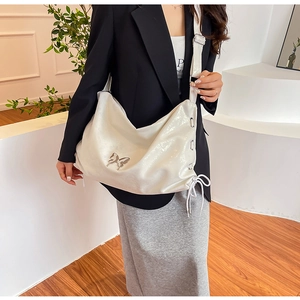Dettaglio borsa shopper bianco perla con farfalla d'argento e lacci laterali