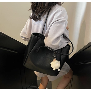 Detail der schwarzen matten Tragetasche mit Fashion trend Prägung und weißem Lamm-Anhänger