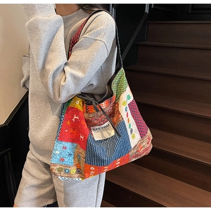 Detail view of ethnic patchwork tote bag with SEEYOU label and drawstring closure