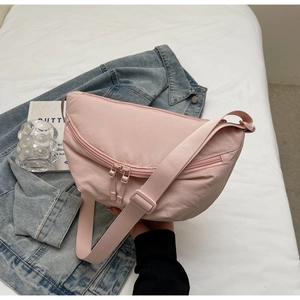 Detailed shot of pink crescent canvas bag with double front zippers and adjustable strap