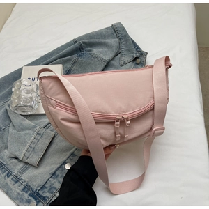Detailed view of pink crescent moon bag with double front zippers and wide strap
