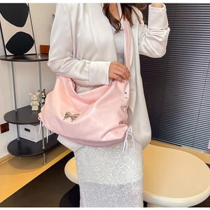 Dettaglio della borsa hobo rosa con fibbia a farfalla e coulisse laterale