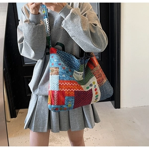 Detail of colorful ethnic patchwork canvas tote bag with wide strap and logo plaque