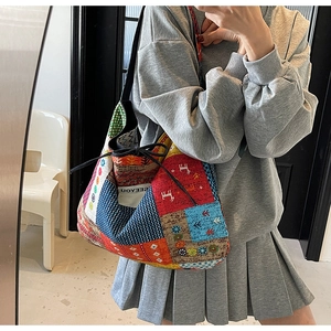 Ethnic style patchwork tote bag with geometric patterns and drawstring closure worn by model