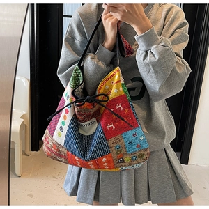 Detail of ethnic canvas tote bag with multi-pattern patchwork and drawstring closure