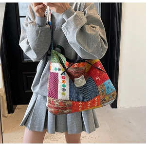 Detail view of ethnic patchwork canvas tote bag with bohemian patterns and brand label