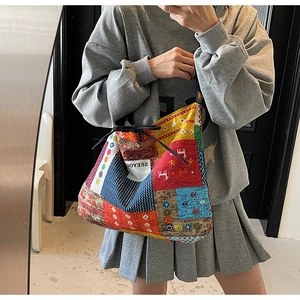 Detail of ethnic canvas tote bag with colorful patchwork patterns and side woven label