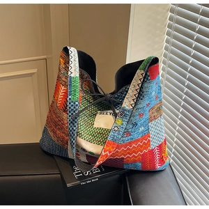 Detail of bohemian patchwork tote bag with ribbon tie on a leather sofa