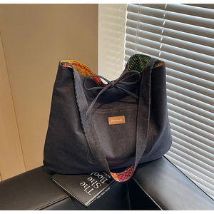Detail of denim tote bag showing colorful floral lining and Jollyhouse brand label