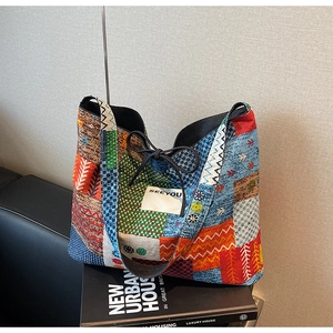 Close-up of colorful canvas tote bag with SEEYOU label and black drawstring detail