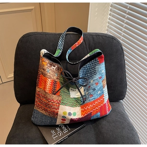 Close-up of ethnic patchwork tote bag with drawstring bow and geometric canvas patterns