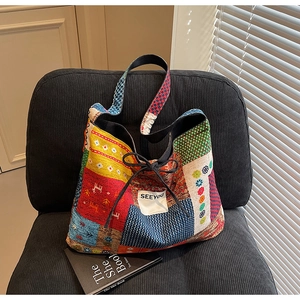 Detailed shot of ethnic patchwork canvas tote bag with SEEYOU label on corduroy chair