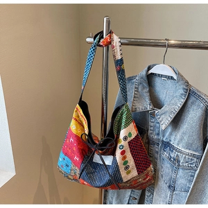 Close-up of bohemian patchwork tote bag featuring colorful patterns and black rope details