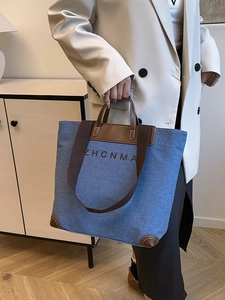 Blue denim and brown leather tote bag with ZHCNMA lettering and wide woven strap
