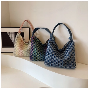 Close-up of vintage tote bags in various colors featuring frayed edges and knotted straps