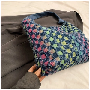 Detail of colorful checkerboard denim tote bag featuring distressed frayed edges texture