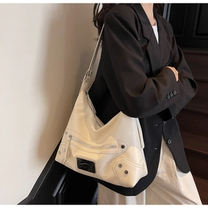 Detail of off-white leather hobo bag with silver studs and zipper accents for women