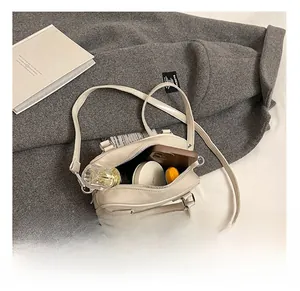 Interior view of the cream leather pillow bag showing space for phone and makeup